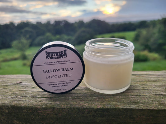 Tallow balm jar and lid with 'Southern Accent' branding on a wooden surface with a scenic background.